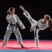 Two girls in taekwondo combat practicing martial arts. They wears kimonos