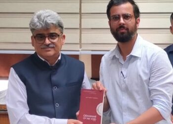Satyarth Pandita presents his book to the Chief Secretary