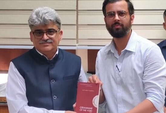 Satyarth Pandita presents his book to the Chief Secretary